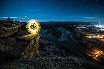 Light painted yellow orb on cliff above river