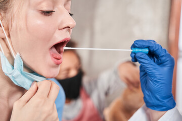 Doctor performs coronavirus swab on caucasian woman