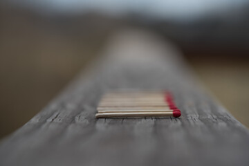 Pattern of red match sticks in a row with first in focus.  Blurred background.