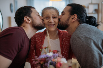 Sons congratulate mom on the holiday. Men visiting their beloved mother on a holiday