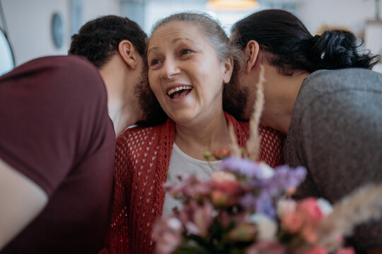 Sons congratulate mom on the holiday. Men visiting their beloved mother on a holiday