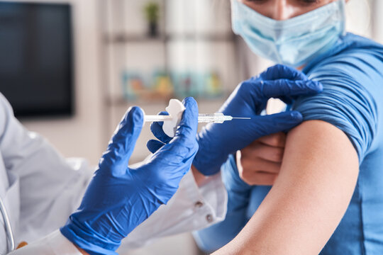 Doctor making vaccination to blonde woman patient