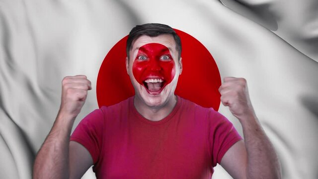 A screaming man with a face painted in the color of the Japanese flag.