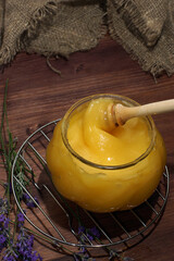 A jar of natural honey next to a lavender bouquet