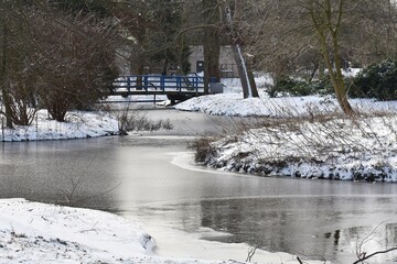 Snowy winter landscape with frozen lake, in the city park. 