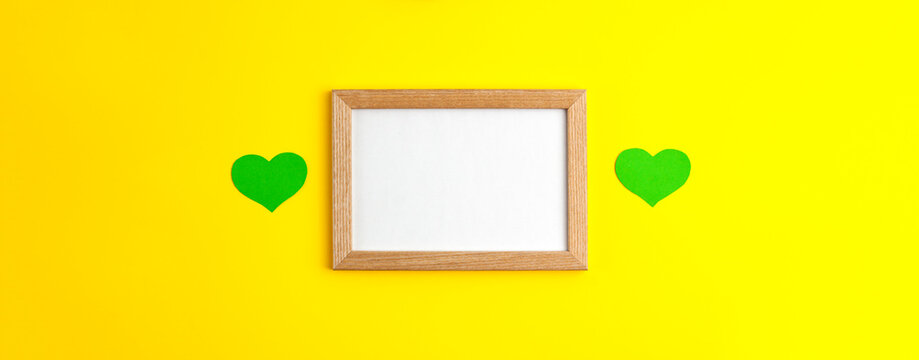 Green paper hearts flat lay mockup, banner on wooden frame in the centre with white copy space on yellow background Saint Patrick's Day 17 march traditional spring celebration holiday and good luck