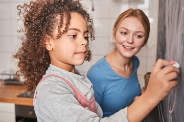 Woman looking with interest at her little multiracial daughter