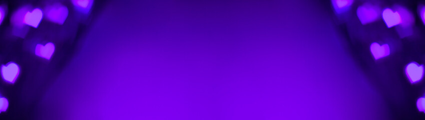 Banner of purple and violet lights makes hears shape bokeh at the left and right. Romantic, love, Valentines day relationship dark background concept with copy space