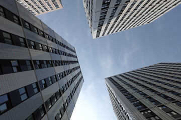 High bottom up perspective view of modern city tower buildings with many windows in the urban cluster