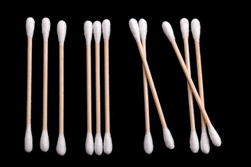 Eco-friendly materials. Wooden, cotton swabs on a black background. Close-up.