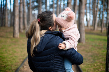 Fototapeta premium Mother with child walking by rural road in forest