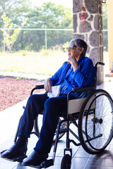 Elderly woman in a wheelchair enjoying the scenery, with dark glasses