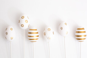 The minimal concept of Easter golden eggs. Stylish Easter golden eggs on a white background. The fashionable Easter lay flat. Happy Easter Greeting card with copy space for text