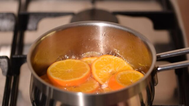 Boiling of tangerine jam in stew pot on hob at home kitchen