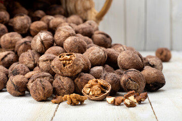 walnuts spilled from the basket on the white wooden