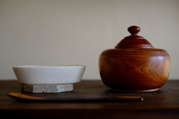 candle and wooden bowl n a dark wooden table