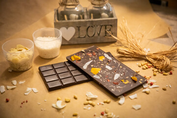 Handmade chocolate with fresh and dried fruits on light paper background in rustic style