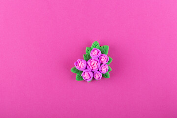 Beautiful rose bouquet made of modelling clay, polymer clay in hearts shape laying on pink background. Top view, copy, space for text