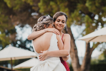 Bridesmaid hugging the bride at the wedding