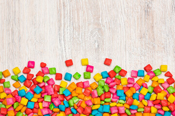 Colored chewing gum on wooden background - Text space