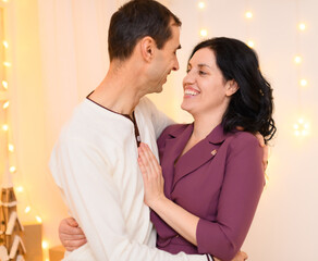 portrait of adult couple in home interior decorated with lights