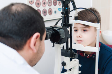Boy with mom on eye examination by ophthalmologist