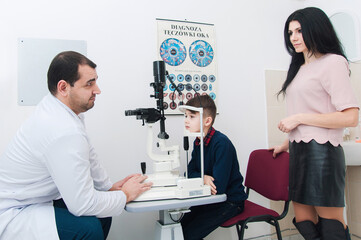 Boy with mom on eye examination by ophthalmologist