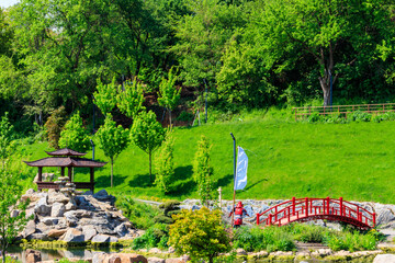 Obraz premium Red bridge and gazebo by a pond in Japanese garden