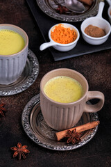 Golden milk with turmeric on dark background, selective focus. Easy Golden Milk Turmeric Latte.
