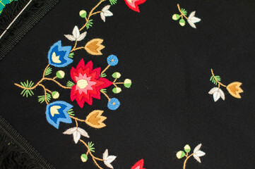 The closeup of the detail of traditional Norwegian vest-coast embroidery ornament, called Frafjord,  on the dark blue woolen fabric