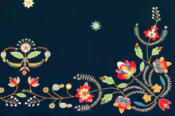 The closeup of the detail of traditional Norwegian vest-coast embroidery ornament, called Løland,  on the dark blue woolen fabric