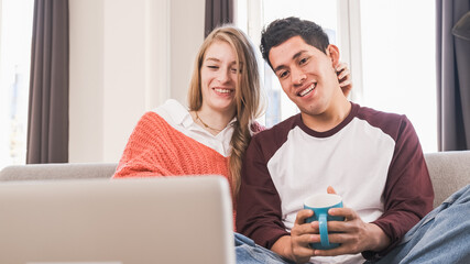 Portrait of a young couple on a video call with their laptop while staying at home.