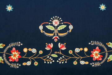 The closeup of the detail of traditional Norwegian vest-coast embroidery ornament, called Løland,  on the black woolen fabric