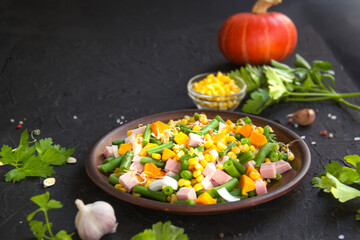 Delicious healthy pumpkin salad with corn and ham. Creative atmospheric decoration