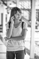 Asiangirl standing at school talking on the smartphone