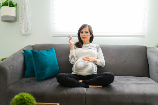 Woman with a risky pregnancy holding a nicotine cigarette