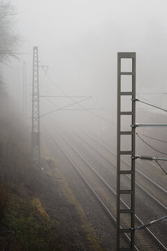 Metal pole at the train line on a foggy day.