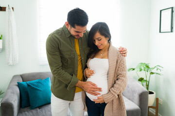 Future parents expecting a baby and hugging at home