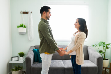 Obraz premium Side view of a pregnant woman and man in love at home