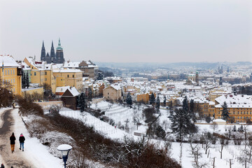 Fototapeta na wymiar Snowy Prague City with gothic Castle from Hill Petrin, Czech republic