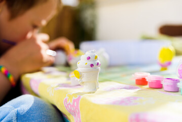 In Montessori schools, children practice art by painting plaster sculptures.