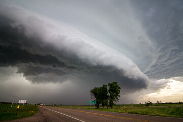 A shelf cloud approaches over a highway in the plains preceding a derecho.