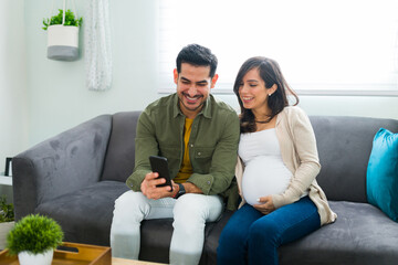 Husband and pregnant wife communicating by video call