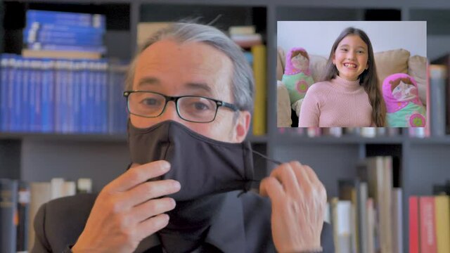 Padre con mascarilla habla por v&iacute;deo con su hija confinada