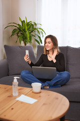 Naklejka premium Caucasian white Teenager girl, using computer and having a video call with her smartphone.