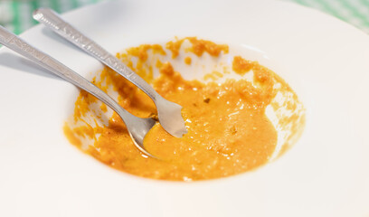 Female hand holding spoon and fork Dirty empty plate put on the plate after eating curry fried rice at the restaurant .