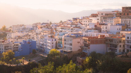 Obraz premium A scenic sunset or sunrise cityscape view over Chefchaouen, Morocco, known as the Blue Pearl with its shades of blue on the town's historic buildings.