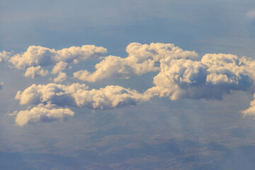 Beautiful white clouds in blue sky. View from airplane