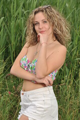 beautiful girl in a swimsuit and glasses on a background of beautiful greenery