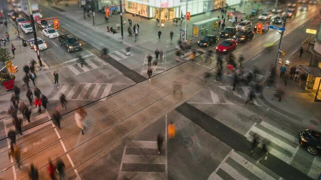 Toronto, Ontario, Canada, zoom out time lapse view of traffic and pedestrians crossing busy intersection at Yonge and Dundas Square.
